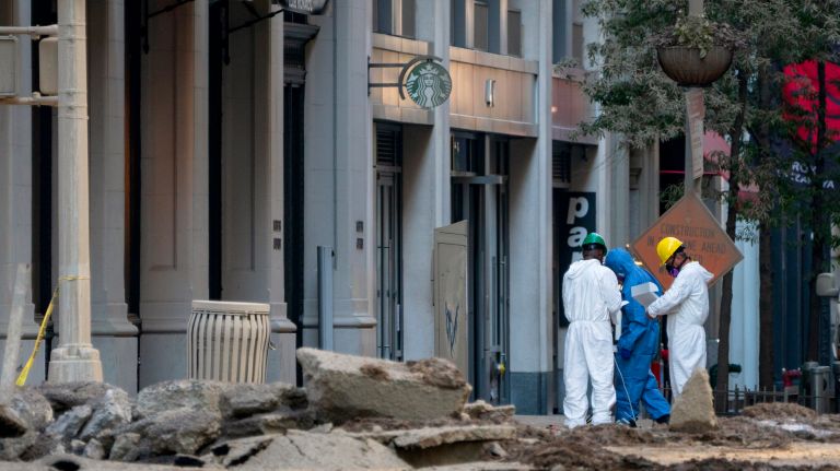 People work Friday at Fifth Avenue and 21st Street at the scene of a steam pipe explosion that sent smoke, mud and steam billowing into the air Thursday morning. Several streets in the area are still closed and buildings off-limits as the cleanup continues.