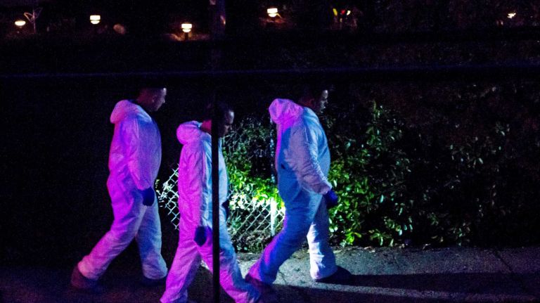 Police investigate the area where an NYPD officer was shot on 104th Road on Saturday, May 2, 2015.