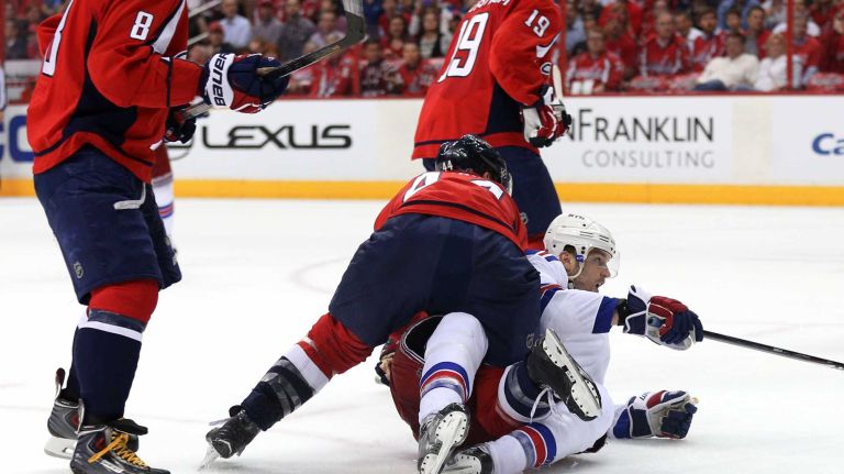Rick Nash #61 of the New York Rangers is body checked by Brooks Orpik #44 of the Washington Capitals during the second period in Game 3 of the Eastern Conference semifinals during the 2015 NHL Stanley Cup playoffs at Verizon Center on May 4, 2015 in Washington.
