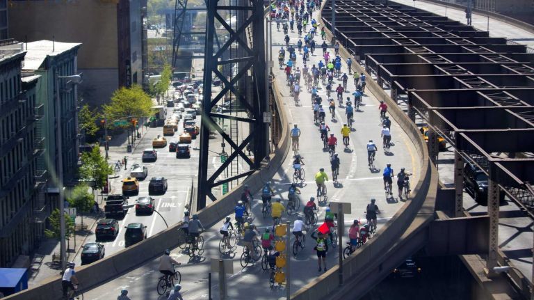 Seen through a window on the Roosevelt Island Tram, participants move across the Ed Koch Queensboro Bridge as they take part in the Five Boro Bike Tour Sunday, May 3, 2015.