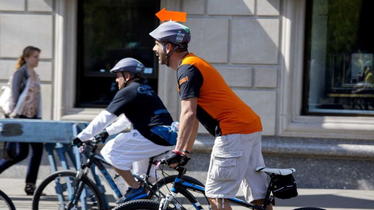 A participant points the way in Manhattan along Central Park South while taking part in the Five Boro Bike Tour Sunday, May 3, 2015.