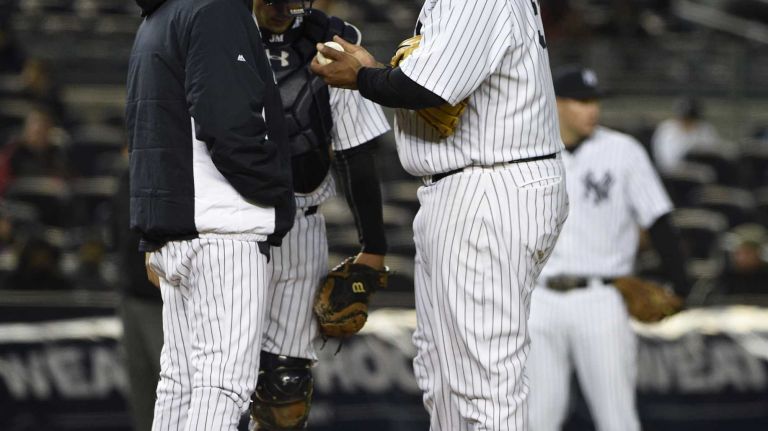 New York Yankees pitching coach Larry Rothschild meets on the mound with catcher John Ryan Murphy and starting pitcher CC Sabathia in second inning against the Toronto Blue Jays in a baseball game at Yankee Stadium on Thursday, April 9, 2015.