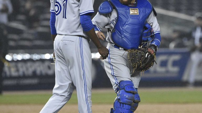 Toronto Blue Jays starting pitcher Miguel Castro and Toronto Blue Jays catcher Russell Martin celebrate their win against the New York Yankees in a baseball game at Yankee Stadium on Thursday, April 9, 2015.