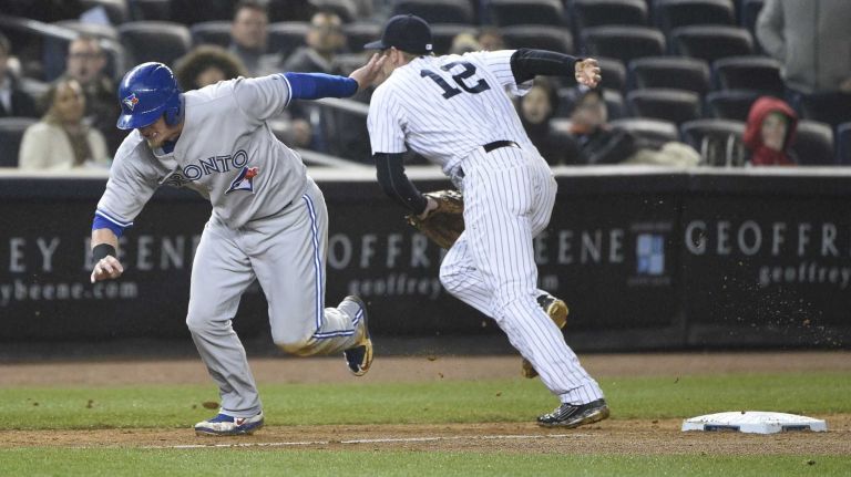 Toronto Blue Jays third baseman Josh Donaldson runs home as New York Yankees third baseman Chase Headley chases after the ball on a throwing error by Carlos Beltran in a baseball game at Yankee Stadium on Thursday, April 9, 2015.