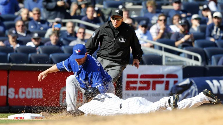 Didi Gregorius #18 of the New York Yankees is caught stealing third base in the eighth inning by Josh Donaldson #20 of the Toronto Blue Jays during Opening Day at Yankee Stadium on Monday, April 6, 2015 in the Bronx Borough of New York City.