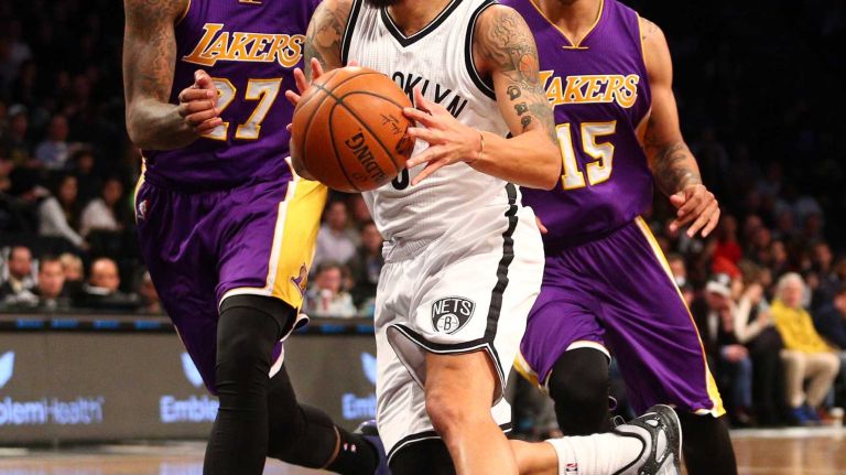 Brooklyn Nets point guard Deron Williams #8 controls the ball against Los Angeles Lakers center Jordan Hill #27 and Los Angeles Lakers shooting guard Jabari Brown #15 during the first quarter of a game at Barclays Center on Sunday, March 29, 2015.