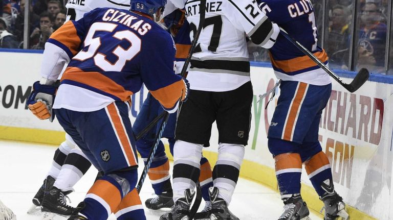 New York Islanders right wing Cal Clutterbuck mixes it up with Los Angeles Kings defenseman Alec Martinez in the third period of an NHL hockey game at Nassau Coliseum on Thursday, March 26, 2015. The Kings defeated the Islanders 3-2.