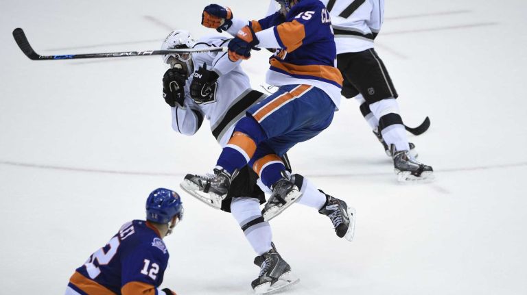 New York Islanders right wing Cal Clutterbuck and Los Angeles Kings defenseman Drew Doughty collide in the second period of an NHL hockey game at Nassau Coliseum on Thursday, March 26, 2015.