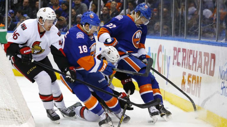 Ryan Strome and Anders Lee of the New York Islanders battle for the puck against Patrick Wiercioch and Cody Ceci of the Ottawa Senators at Nassau Coliseum on Friday, March 13, 2015.