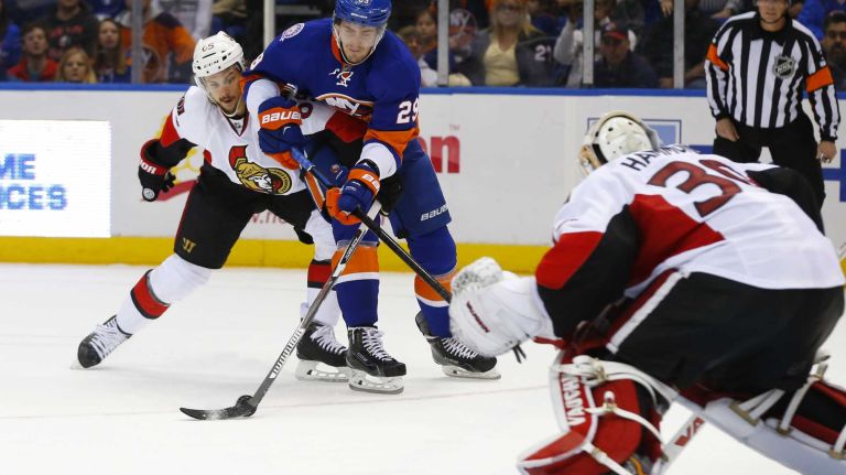 Erik Karlsson of the Ottawa Senators defends against Brock Nelson of the New York Islanders late in the third period at Nassau Coliseum on Friday, March 13, 2015.