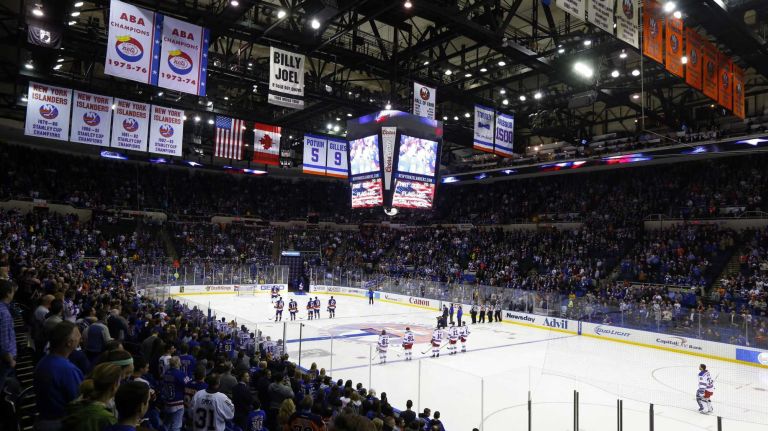 The New York Islanders and the New York Rangers stand during the national anthem before their game at Nassau Coliseum on Tuesday, March 10, 2015.