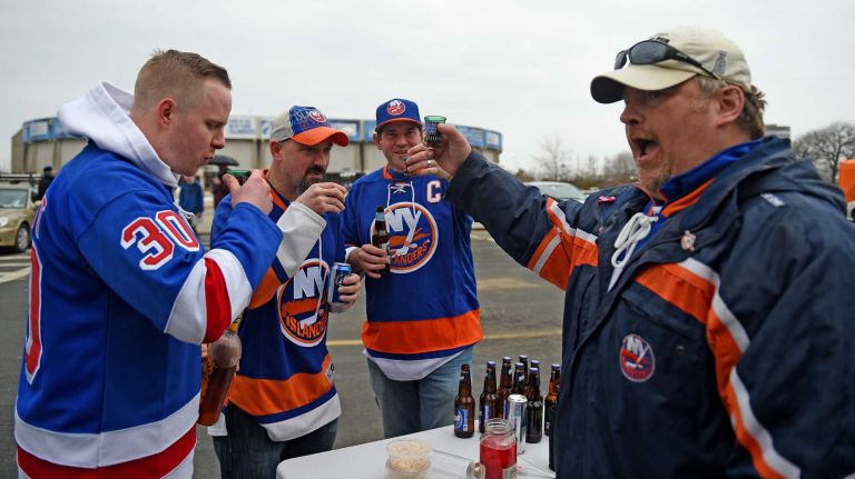 Fans at Islanders vs. Rangers 44 James McCaffrey of Port Washington, James Fenwick and Rich Finley of Kamloops, Canada, and Alex Klein of Roslyn toast in the parking lot of Nassau Coliseum before the last Islanders-Rangers regular-season game at the Coliseum on March 10, 2015.