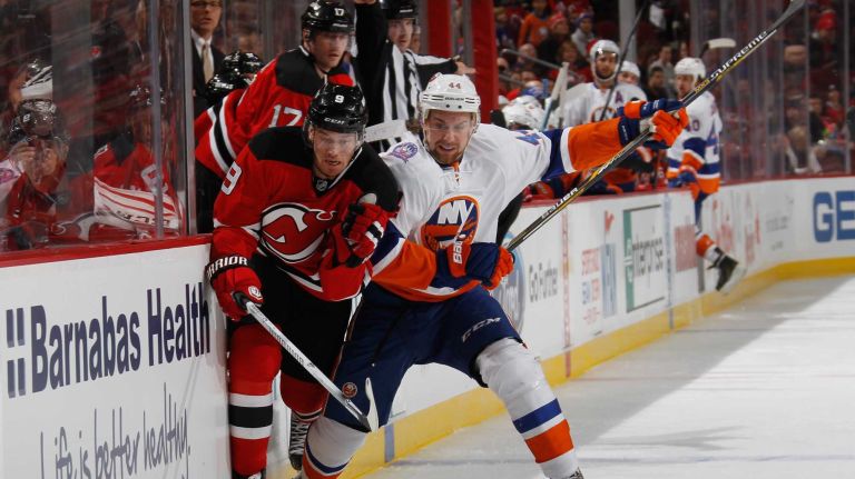 Martin Havlat of the New Jersey Devils is checked by Calvin de Haan of the New York Islanders during the second period at the Prudential Center on Jan. 9, 2015 in Newark, N.J.