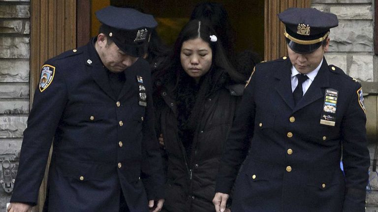 NYPD officers escort Pei Xia Chen, the wife of slain Det. Wenjian Liu, as she leaves her house in Brooklyn on Jan. 4, 2015, for the funeral of her husband of two months.