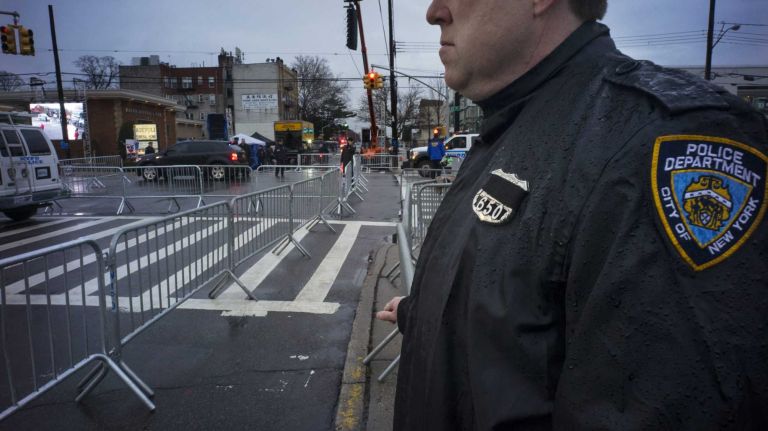 An NYPD officer stands at the site in Brooklyn near where other officers will line the streets on Jan. 4, 2015, for the funeral of slain Det. Wenjian Liu. 