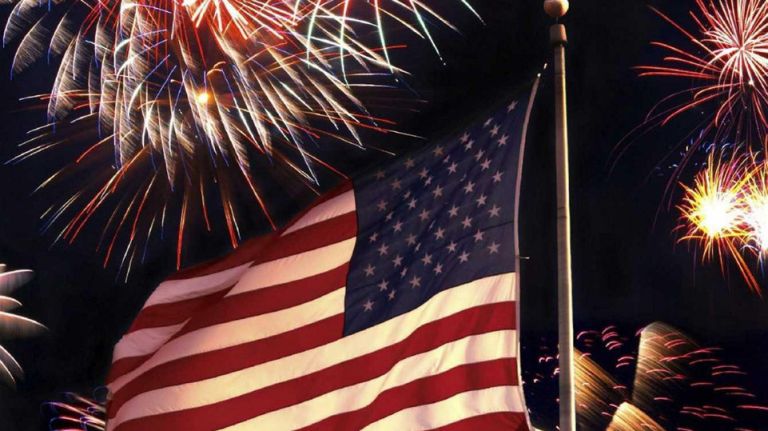 Sorry, no three-day weekend for you 1 Fireworks go off around an American flag.