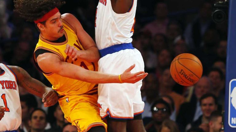 Anderson Varejao of the Cleveland Cavaliers passes the ball past Quincy Acy of the New York Knicks at Madison Square Garden on Thursday, Dec. 4, 2014.