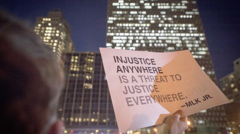 A demonstrator holds up a quote from the Rev. Martin Luther King Jr. at Foley Square in New York City on Thursday, Dec. 4, 2014, in the wake of a Staten Island after a grand jury decided not to indict NYPD officer Daniel Pantaleo in the death of Eric Garner on July 17, 2014.