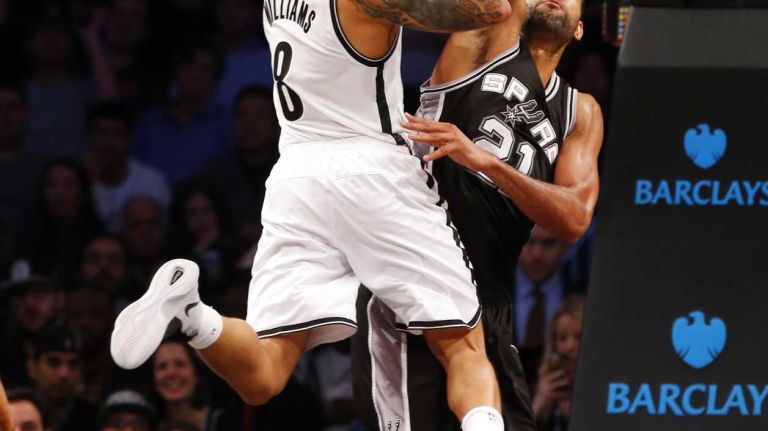Deron Williams of the Brooklyn Nets goes to the hoop against Tim Duncan of the San Antonio Spurs during an NBA game at Barclays Center on Wednesday, Dec. 3, 2014.