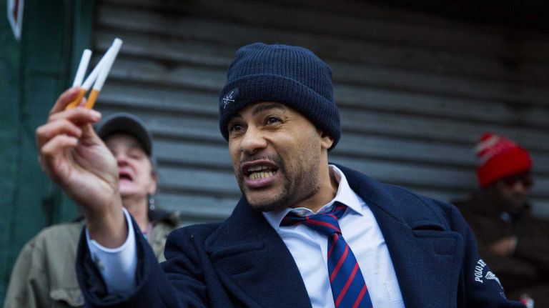 Daniel Skelton of Rahway, N.J., holds cigarettes as he protests a grand jury decision Wednesday, Dec. 3, 2014, near the spot where Eric Garner died in July while he was being put into police custody. 