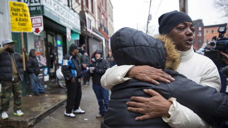 People embrace on Wednesday, Dec. 3, 2014, near the spot on Staten Island where Eric Garner was being arrested in July. A grand jury on Wednesday decided not to indict NYPD Officer Daniel Pantaleo in Garner's death.