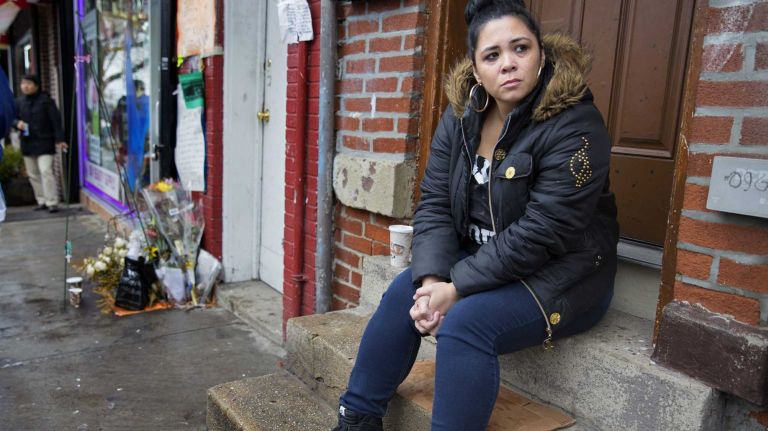 Heather Ewig of Staten Island, who says she knew Eric Garner from the neighborhood, sits on Wednesday, Dec. 3, 2014, near the spot (left) where Garner died while he was being taken into police custody in July. 