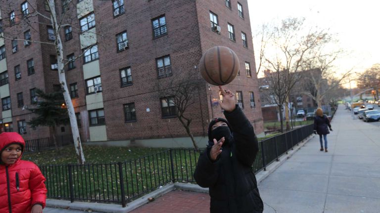 Ziyeer Smith, 12 ( in blue), and Taejon Tyson, 11 ( in red), play with a basketball outside the Soundview Houses on Seward Ave. in the Soundview section of the Bronx, Thursday, Nov., 20, 2014.