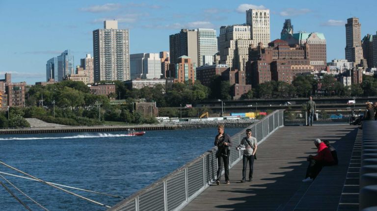 People walk on on the East Side Esplanade