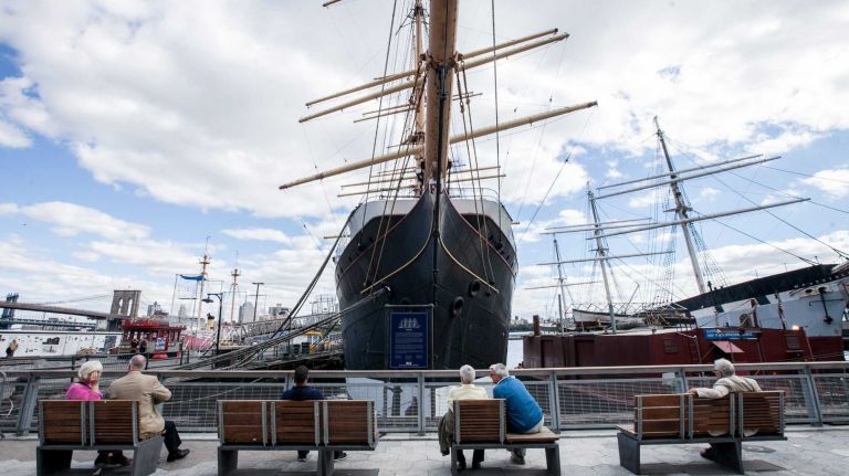 People sit on the pier in front of the Peking
