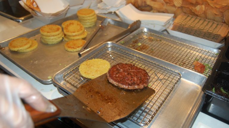 When the patty is done, place it on top of the arugula. 