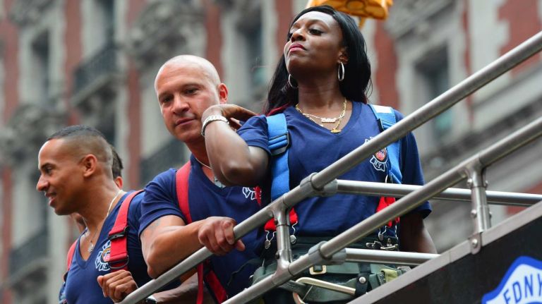 Danae Mines, an 11 year FDNY veteran and first woman to be featured in the Calendar of Heroes, gets ready for her close-up in Times Square on July 15, 2014.