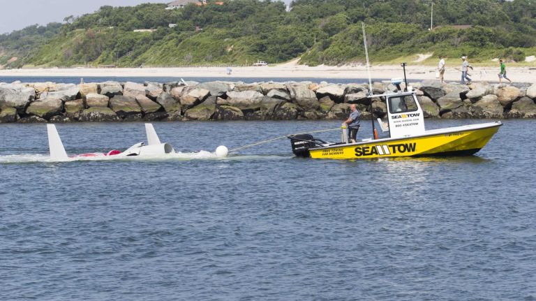 The wreckage of a single-engine plane that crashed into Long Island Sound is towed by Seatow through the Mattituck Inlet on Monday, July 7, 2014.