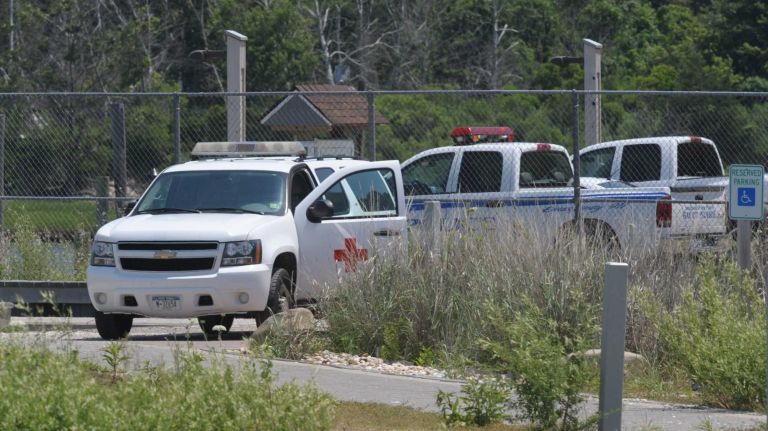 The medical examiner's van, Southold Town police and Mattituck fire and rescue personnel on the scene at Mattituck Inlet, near where a small airplane crashed in the Long Island Sound on Monday, July 7, 2014.