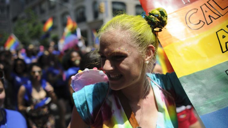 Participants walk in the New York City pride parade in Manhattan on Sunday, June 29, 2014. The march commemorates 45 years since bar patrons rebelled against police raids on their gathering places and jump-started the LGBT-rights movement.