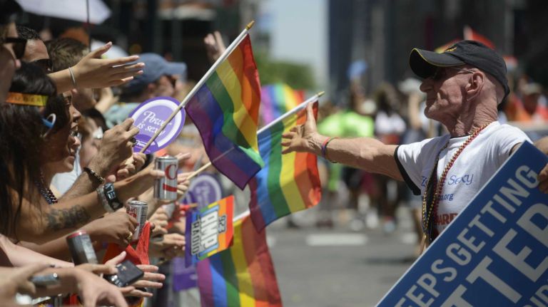 A participant in the New York City Pride Parade reaches out to spectators in Manhattan on Sunday, June 29, 2014.