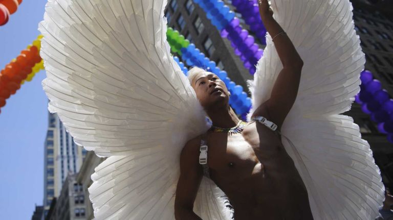 One participant walks under a colorful arch of balloons at the New York City Pride Parade in Manhattan on Sunday, June 29, 2014.