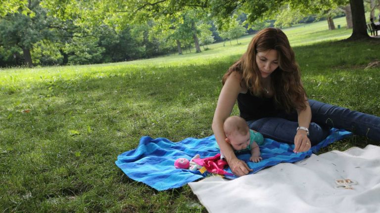 Patricia Garcia and daughter, Eleana, relax in the grass in Inwood Hill Park in Inwood, Thursday, June 20, 2014. 