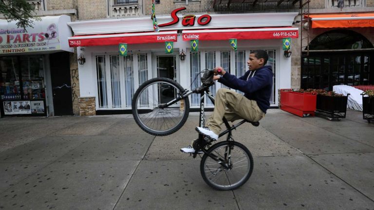 Kevin Montes, 15, practices his bicycle tricks along Dyckman St. near Seaman Ave. in Inwood, Thursday, June 19, 2014. 