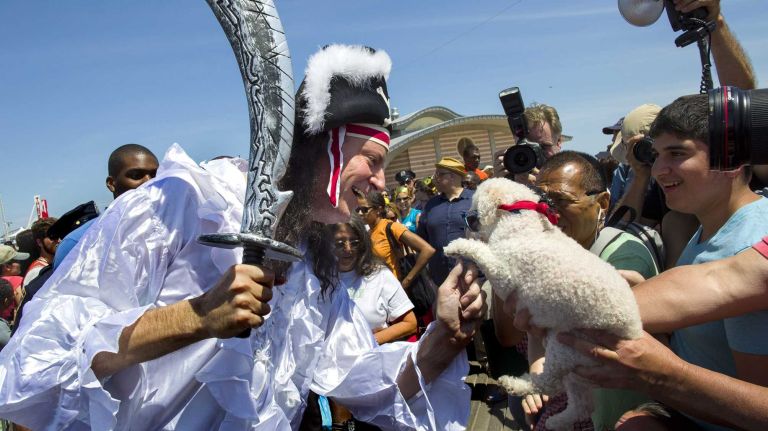 New York City Mayor Bill de Blasio greets a crowd and a dog on the boardwalk as he marches in the annual Coney Island Mermaid Parade on Saturday, June 21, 2014.