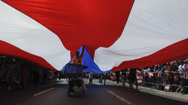 Participants march with a giant Puerto Rican flag during the 57th annual National Puerto Rican Day Parade in Manhattan on Sunday, June 8, 2014.