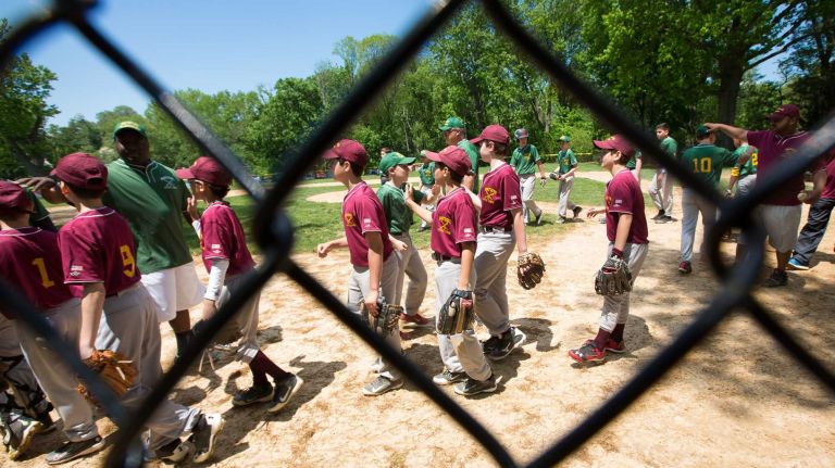 Players and coaches shake hands after a Little League baseball game at Crocheron Park on Saturday, May 17, 2014. 