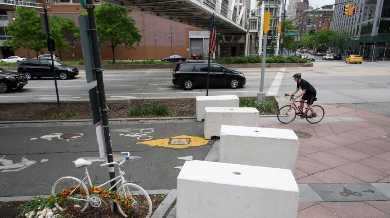 A bicyclist rides between concrete barriers along the Hudson River Park Bikeway at Chambers Street on Sunday. The barriers were placed along the bikeway after eight people were killed and 15 injured during a vehicular lone-wolf terror attack.