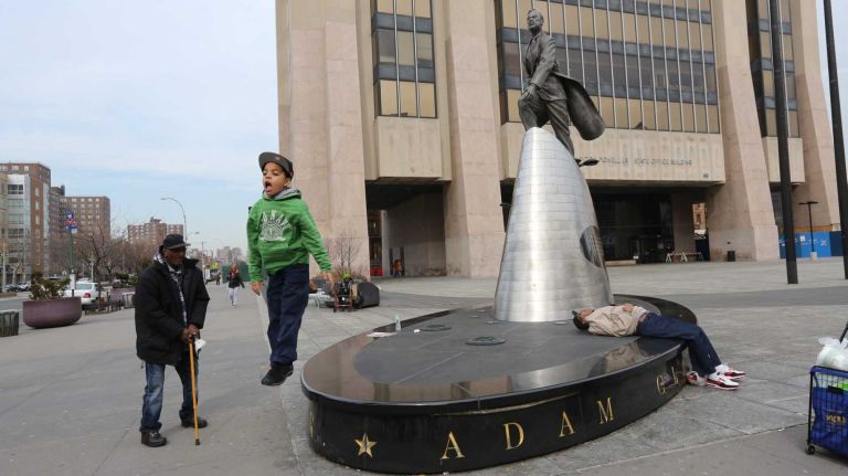 Children play near the statue of Adam Clayton Powell, Jr. outside the Adam Clayton Powell, Jr. State office building at 163 W. 125th street in Harlem, Wednesday, April 2, 2014.