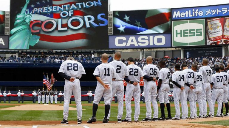 The New York Yankees stand for the national anthem before the home opener against the Baltimore Orioles at Yankee Stadium on Monday, April 7, 2014.
