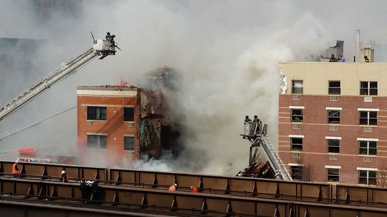East Harlem explosion 12 Firefighters battle a blaze at the site of an explosion and possible building collapse in East Harlem on Wednesday, March 12, 2014.