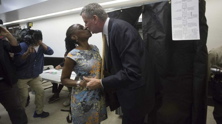 Democratic mayoral candidate Bill de Blasio kisses his wife, Chirlane McCray, as he emerges from a voting booth after casting his ballot in New York City's primary election on Sept. 10, 2013 at the Park Slope Branch Public Library in Brooklyn.