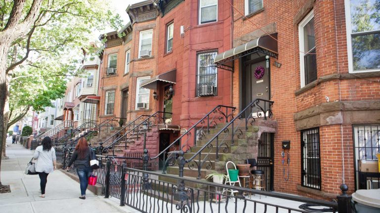 A row of brownstone buildings lines 43rd Street. 