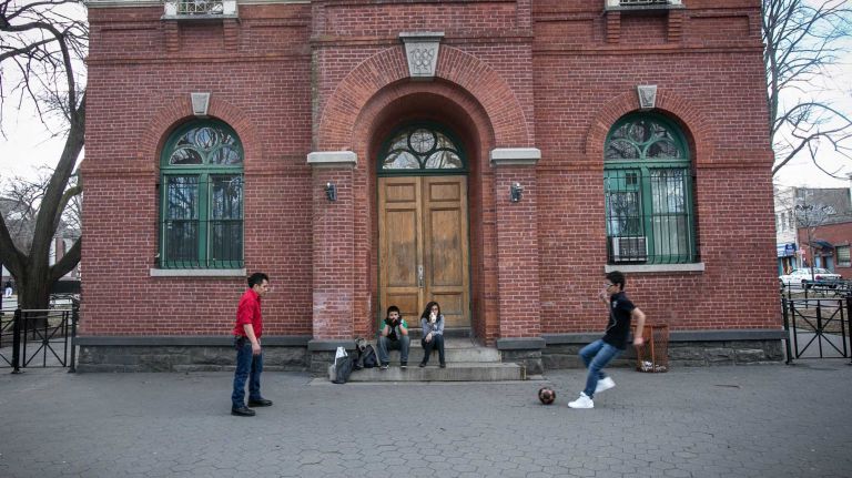 Visitors to Tappen Park kick a soccer ball in front of the Romanesque comfort station. (Mar. 30, 2013)