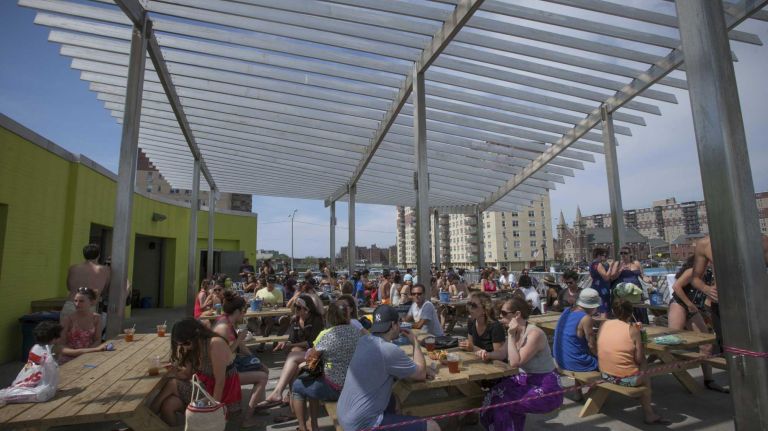 Tables for hungry visitors to Rockaway Beach are set up under a new pavilion. 