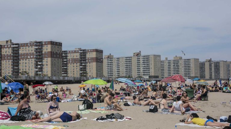 Gigantic apartment buildings loom over Rockaway Beach, a not-so-subtle reminder that you're still in the city. 